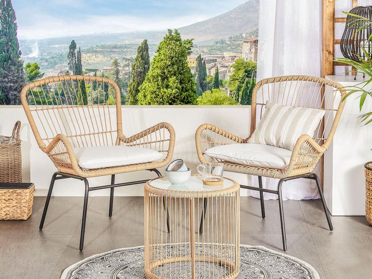 Terrasse mit zwei Rattansesseln, Beistelltisch, Kissen und dekorativen Elementen