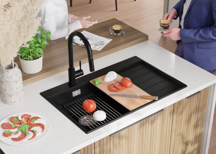 Küchenspüle mit Schneidebrett, Abtropfgestell und Armatur auf einer Küchentheke mit Zutaten für Caprese-Salat und zwei Personen