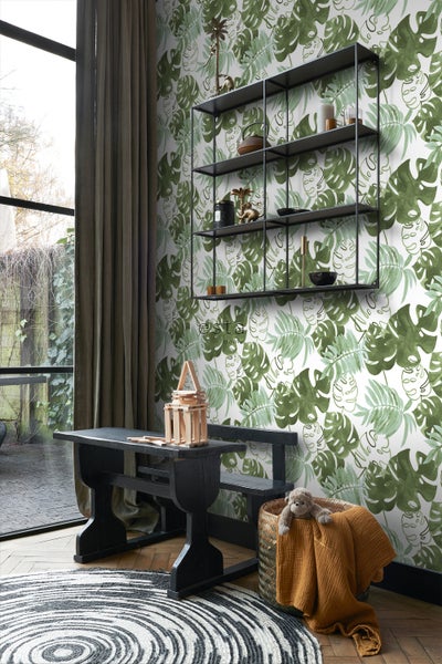 Wohnraum mit einer Bank, einem Regal und einer Tapete mit Blattmuster