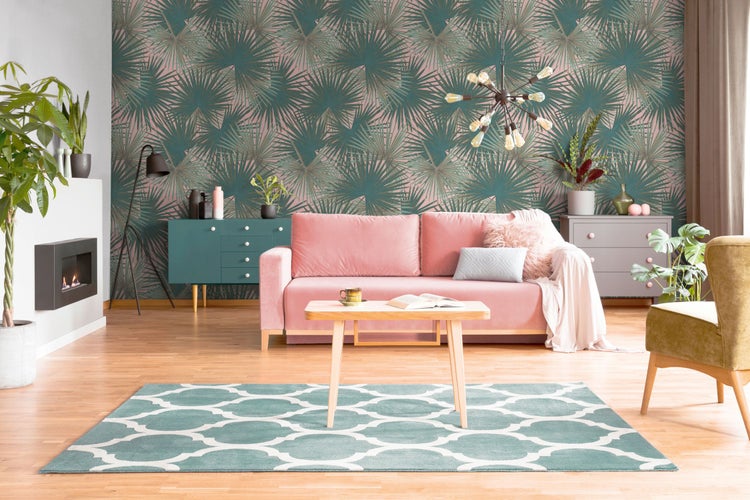 Wohnzimmer mit Sofa, Tisch, Teppich und gemusterter Tapete