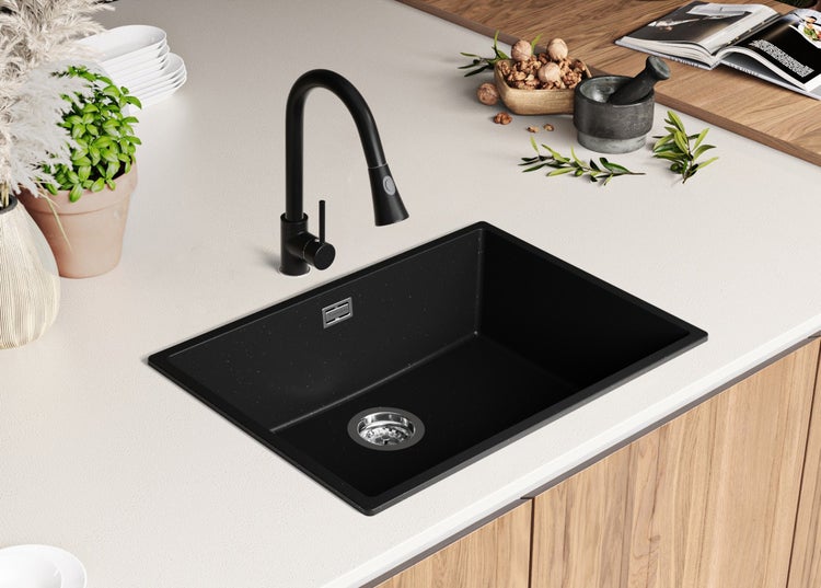 Schwarzes Spülbecken mit Wasserhahn auf einer Küchentheke.