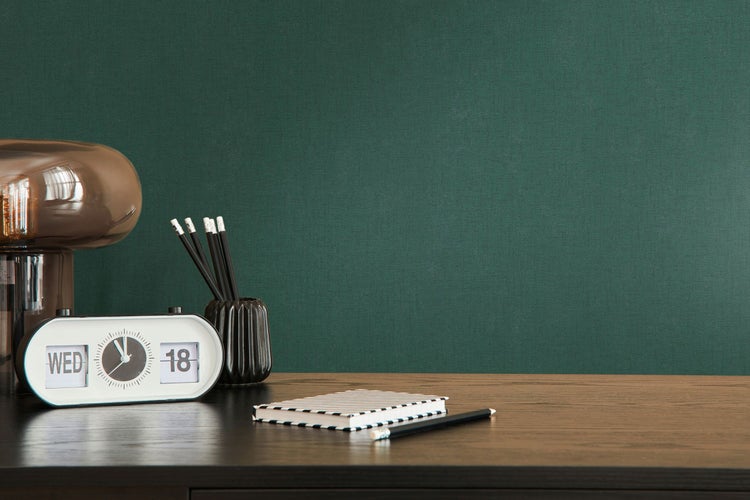 Dekorative Szene mit Pflanze in Papiertüte, Bücherstapel und Kommode