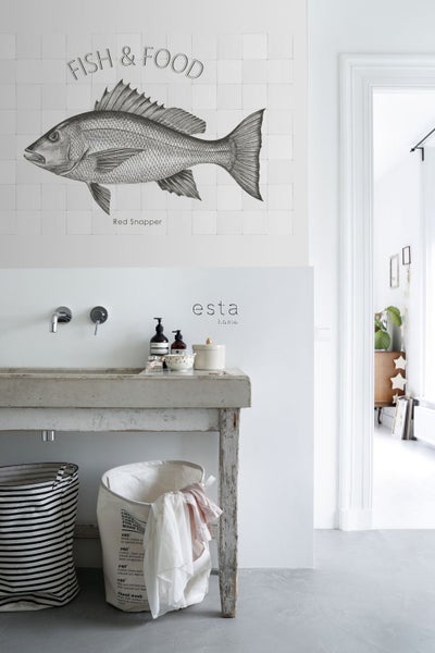 Badezimmer mit Waschbeckenunterschrank, Wäschekörben und Wanddekoration mit Fischmotiv