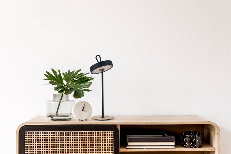 Dekoratives Sideboard mit Lampe, Vase, Uhr und Büchern für ein stilvolles Ambiente