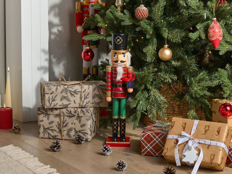 Weihnachtliche Szene mit Nussknacker, Geschenken und geschmücktem Weihnachtsbaum