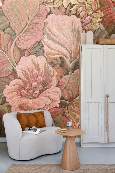 Dekoratives Wohnzimmer mit blumiger Tapete, Sessel, Beistelltisch und Schrank