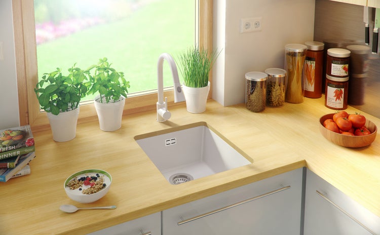 Küchenszene mit Spüle, Armatur, Lebensmitteln und Dekoration auf einer Arbeitsplatte