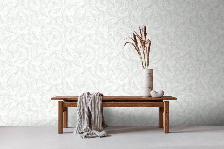 Raumansicht mit gemusterter Tapete, Holzbank, Decke, Vase und Dekoration.