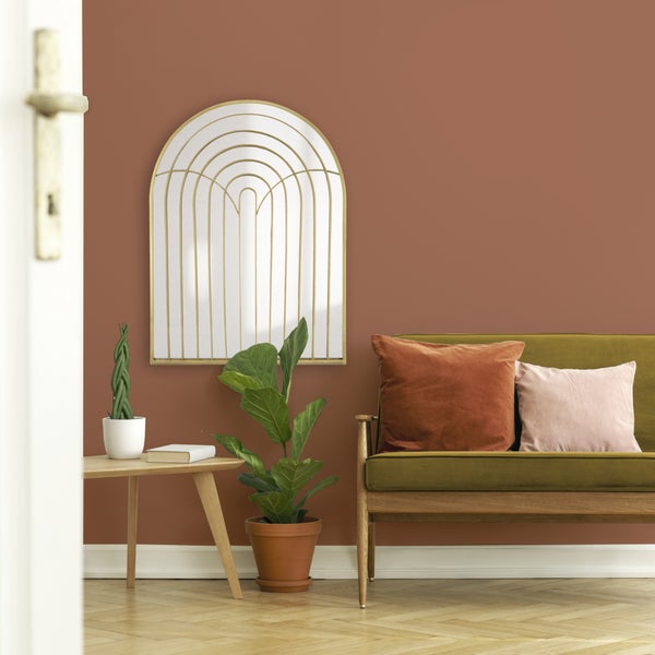 Modernes Wohnzimmer mit großem Bogenwandspiegel mit goldenem Rahmen, olivgrünem Samtsofa und terrakottafarbenen Wänden.