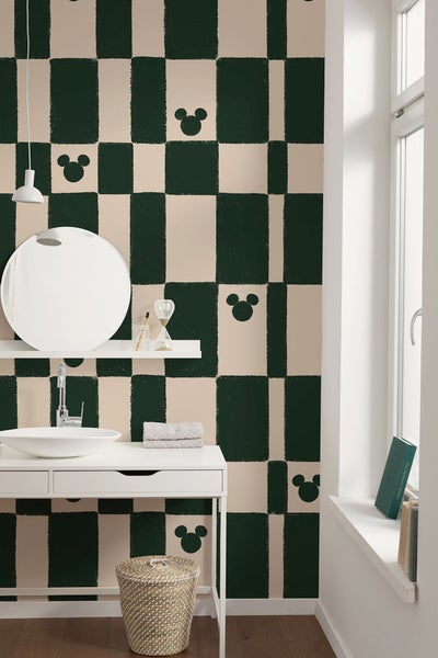 Badezimmer mit Waschbecken, Spiegel und Tapete mit grafischem Muster und Mickey Mouse Motiven