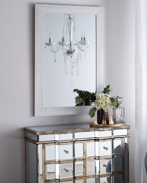 Dekoratives Zimmer mit Spiegel, Kommode und Blumenarrangement