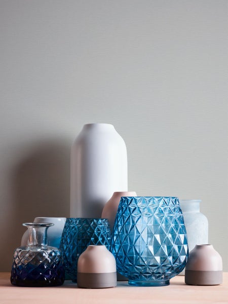 Schlafzimmer mit Doppelbett, Nachttisch, Lampe und Teppich mit Zickzackmuster