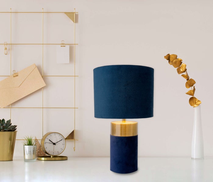 Dekorative Tischleuchte mit blauem Lampenschirm und goldenem Sockel auf einem Tisch