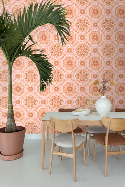 Esszimmer mit Esstisch, Stühlen, Topfpflanze und gemusterter Tapete