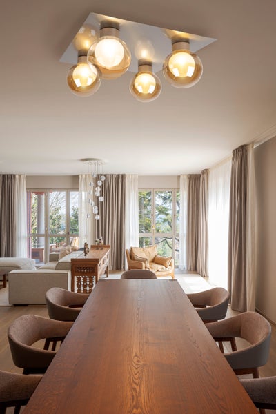 Helles Esszimmer mit Holztisch, Stühlen und Deckenleuchte mit Glaskugeln