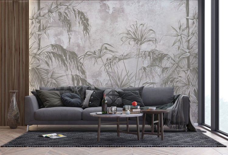 Wohnzimmer mit grauer Couch, Kissen, Tisch und botanischer Tapete