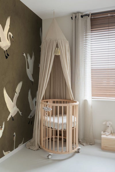 Zimmer mit rundem Kinderbett, Baldachin und Tapete mit Schwanenmotiven