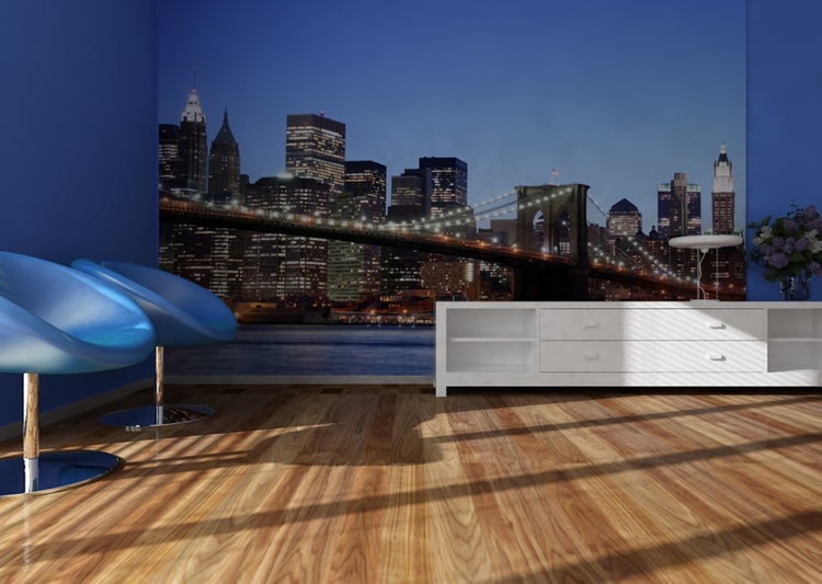 Wohnzimmer mit New York Skyline Wandbild, zwei Stühlen und weißem Sideboard.