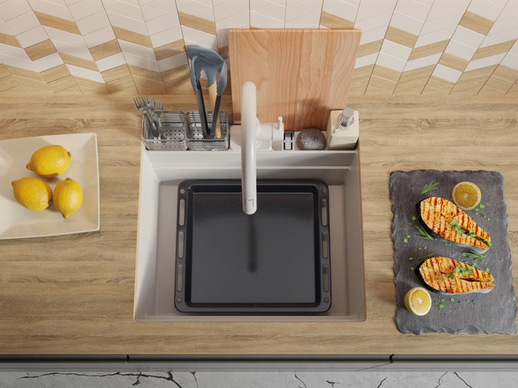 Spüle mit Abtropffläche, Backblech und Küchenutensilien auf einer Arbeitsplatte