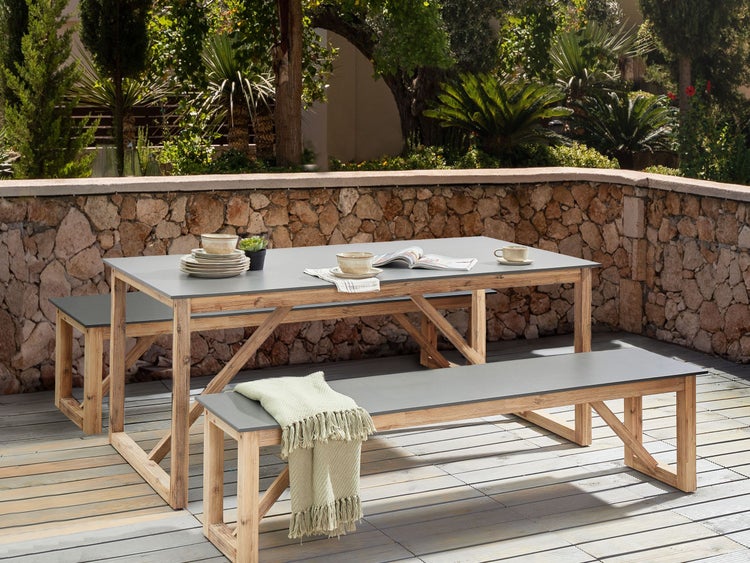 Gartenszene mit Esstisch und zwei Bänken auf einer Terrasse