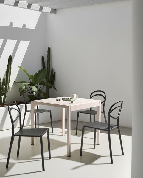 Gartenszene mit Tisch, Stühlen, Pflanzen und Spiel