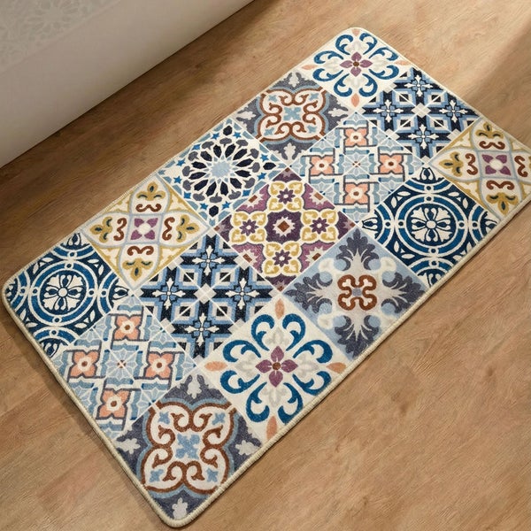 Rechteckige Badematte mit Fliesenmuster im Patchwork-Design auf einem Boden in Holzoptik neben einer Badewanne.