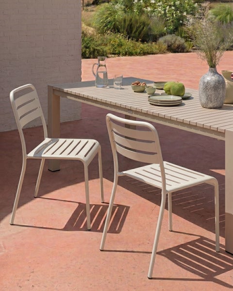 Modernes Gartenmöbel Set aus Metall mit Lattenstruktur bestehend aus einem rechteckigen Gartentisch und zwei Gartenstühlen auf einer Terrasse