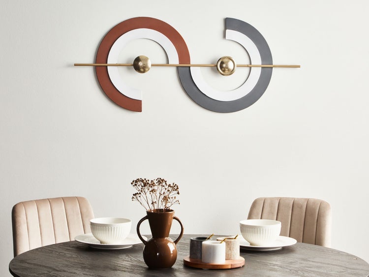 Dekorative Wandkunst über einem gedeckten Esstisch mit Stühlen