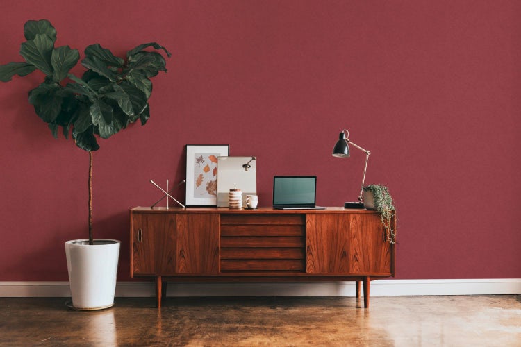 Schlafzimmer mit Bett, Leiter und Rattansessel auf Holzboden