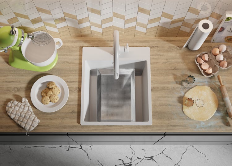 Küchenszene mit Spüle, Armatur und Backutensilien auf der Arbeitsplatte.