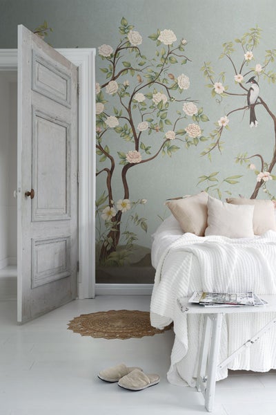 Schlafzimmer mit floraler Tapete, Bett und Nachttisch