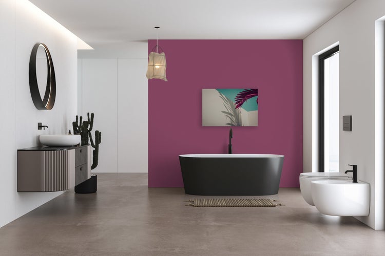 Modernes Badezimmer mit freistehender Badewanne, wandhängendem Waschbecken und Wandbild vor einer kräftig beerenfarbenen Wand.