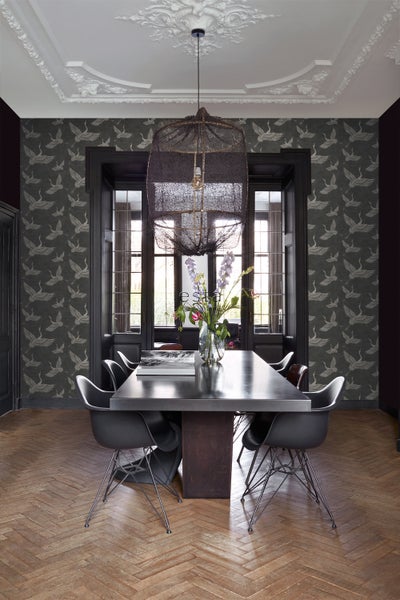 Esszimmer mit Esstisch, Stühlen, Lampe und gemusterter Tapete