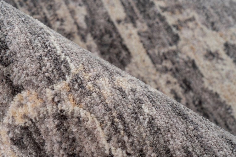 Detailansicht eines Teppichs mit abstraktem Muster und strukturierter Oberfläche.