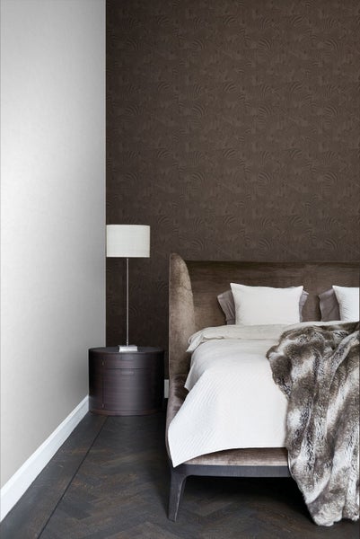 Modernes Schlafzimmer mit brauner Mustertapete, gepolstertem Bett und dunklem Nachttisch neben einer hellen Wand.