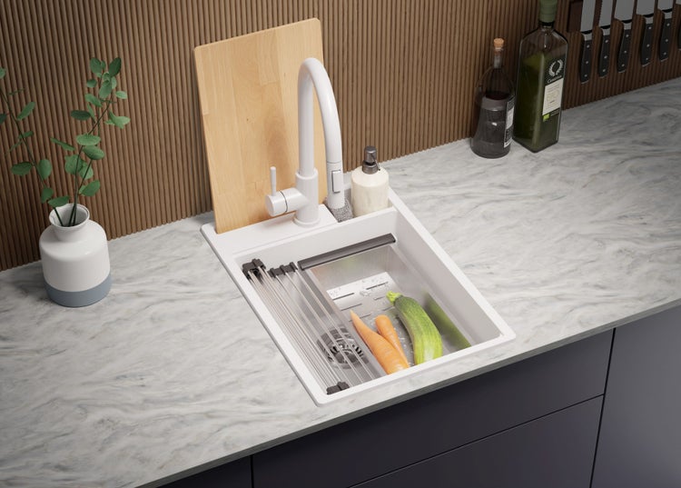 Küchenszene mit Spüle, Armatur, Schneidebrett und Gemüse auf einer Küchentheke.