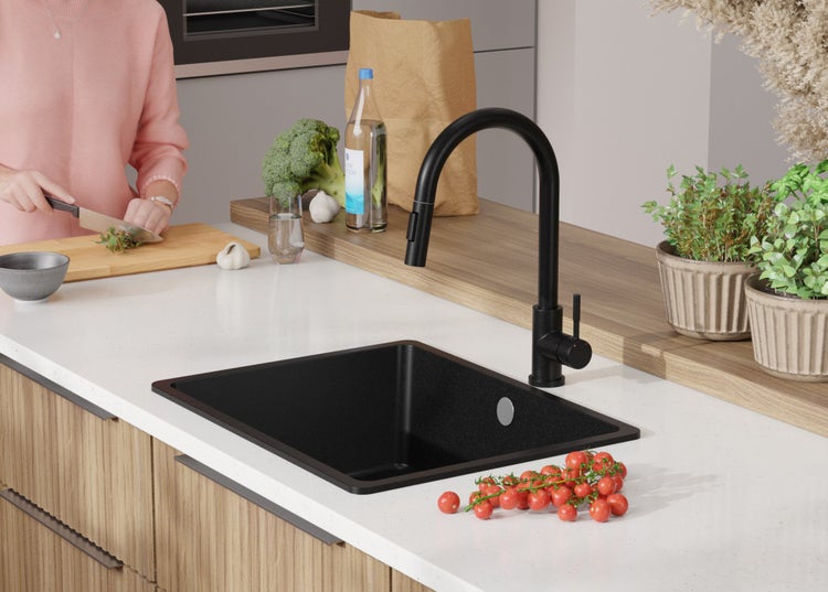 Küchenszene mit schwarzem Spülbecken und Armatur auf einer Küchentheke.