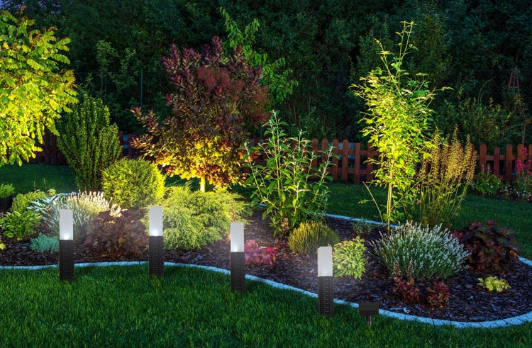 Gartenlandschaft mit Wegleuchten und üppiger Bepflanzung