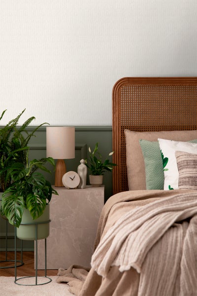 Schlafzimmer-Interieur mit Holzbettgestell, Nachttisch und Zimmerpflanzen