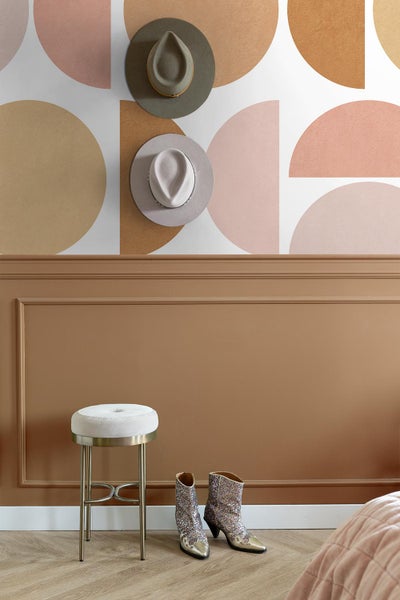 Dekoratives Zimmer mit Stuhl, Stiefeln und Tapete mit geometrischem Muster.
