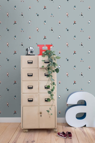 Innenraum mit Tischfußball, Pflanze und dekorativer Wand