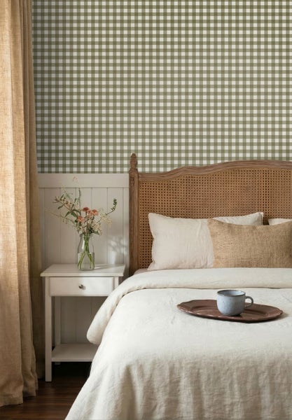 Schlafzimmer mit grün-weiß karierter Tapete, Holzbett mit Wiener Geflecht am Kopfteil, weißem Nachttisch und heller Bettwäsche.