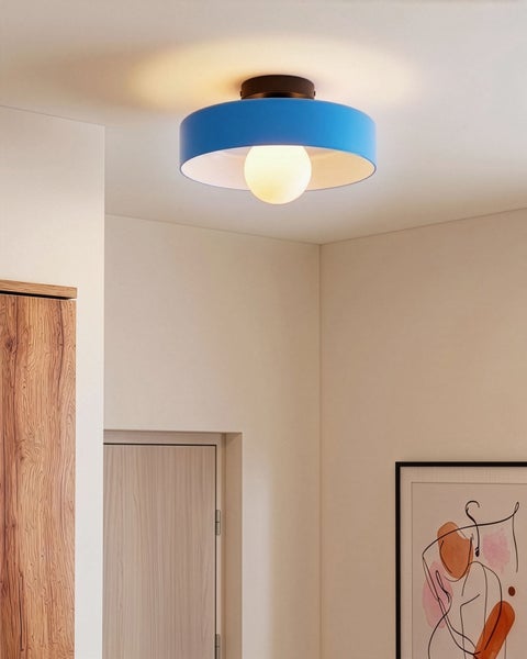 Moderne Deckenleuchte mit blauem Schirm in einem hellen, minimalistischen Raum mit Holzschrank und abstrakter Kunst.