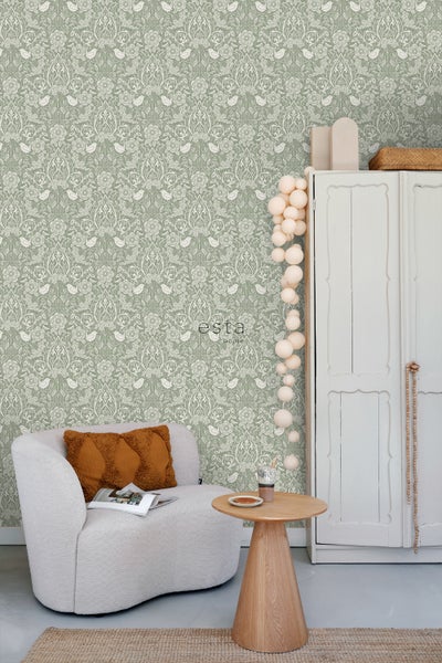 Zimmer mit grüngemusterter Tapete, Sessel und Tisch