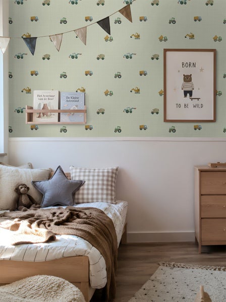 Kinderzimmer mit Tapete mit Fahrzeugmuster an der oberen Wand, Holzbett, Kommode und dekorativen Elementen.