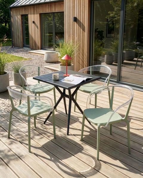 Gartenszene mit einem quadratischen Tisch und vier Stühlen auf einer Holzterrasse