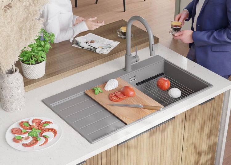 Küchenszene mit Spüle, Armatur, Schneidebrett, Tomaten, Mozzarella und Geschirr