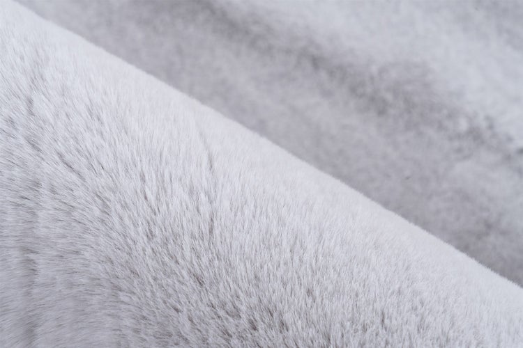 Detailaufnahme der weichen Fasern eines Kunstfell-Teppichs aus Polyester.