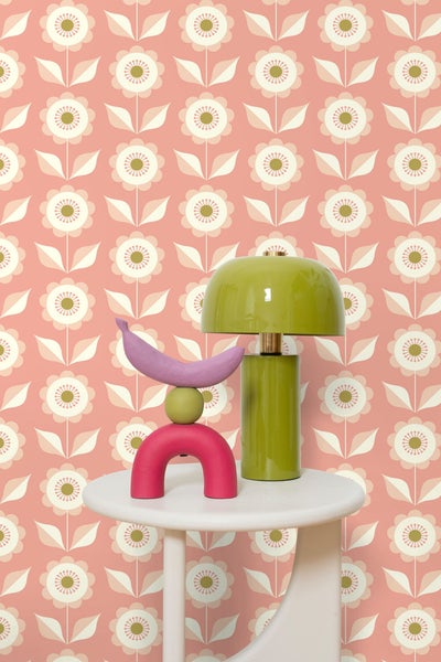 Dekorative Stillleben-Komposition mit Lampe, Obst und abstrakter Kunst auf einem Beistelltisch vor einer floralen Tapete