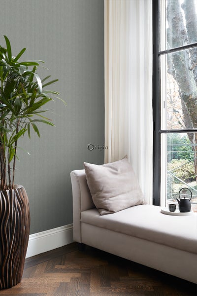 Innenraumszene mit gemusterter Tapete, Pflanze im Topf und Liege mit Kissen am Fenster